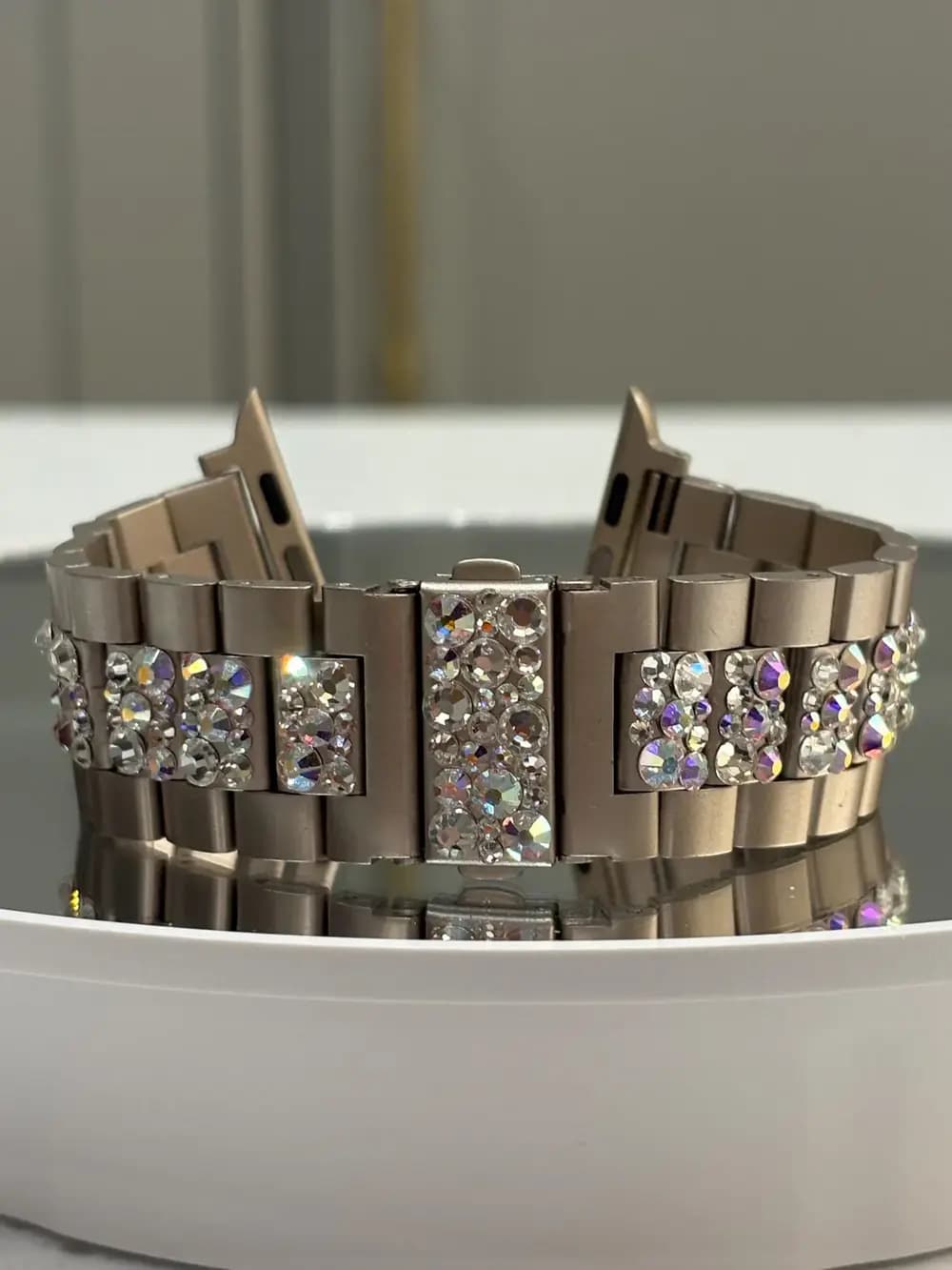 Swarovski Crystal Smart Watch Bracelet with sparkling crystals on a stainless steel strap, showcased on a reflective surface.
