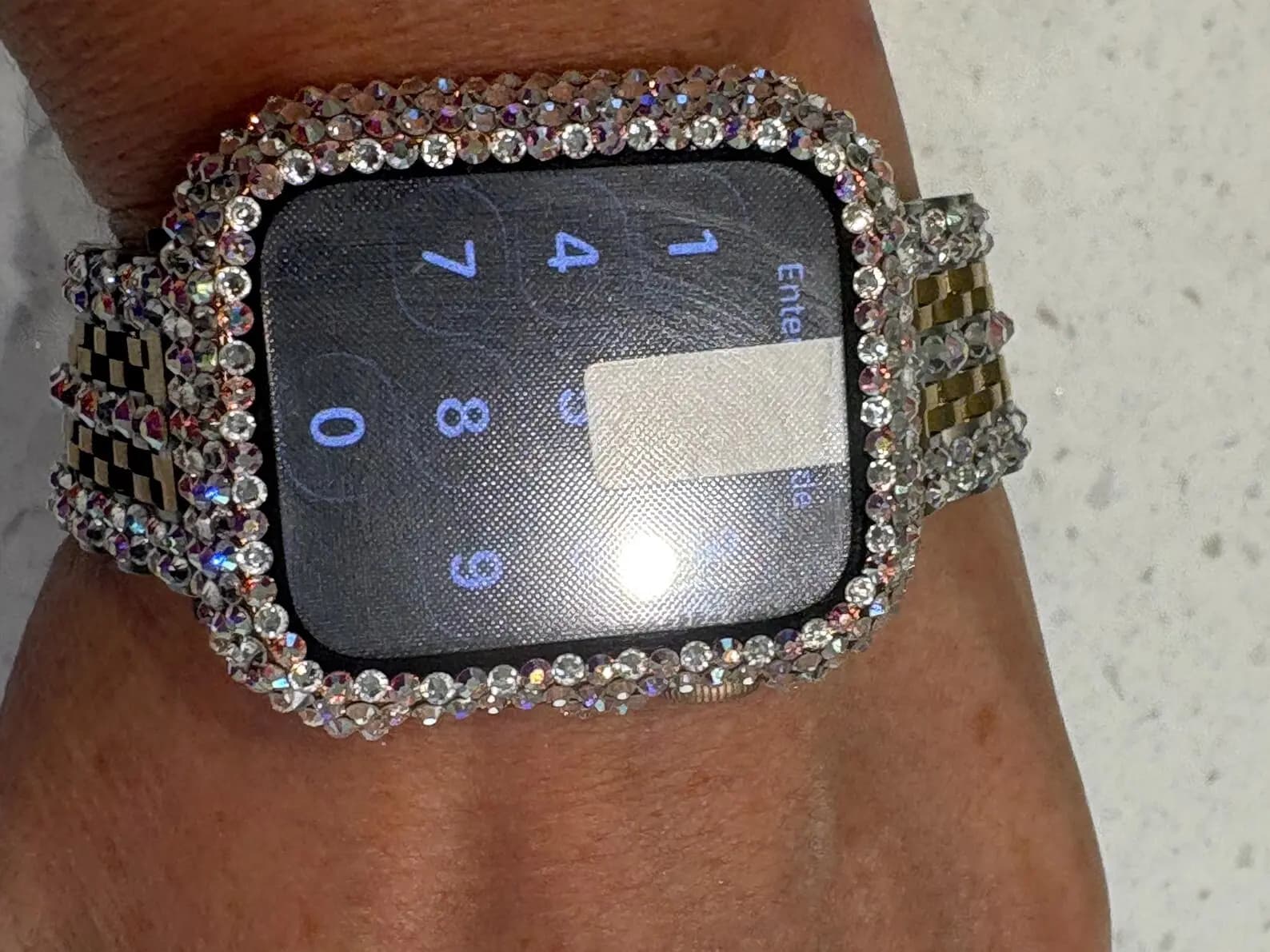 Luxury Watch Screen Case with Preciosa® Crystals, showing a locked smart watch face, and a crystal-encrusted bezel and band.