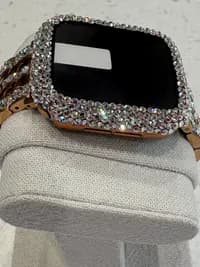 Luxury Watch Screen Case with Preciosa® Crystals, featuring a gold tone and sparkling crystal embellishments, displayed on a fabric stand.