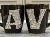 Personalized Crystal Initial Mug with letters "A" and "V" in sparkling crystals on black ceramic, shown from the front.