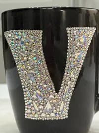 Personalized Crystal Initial Mug featuring a large "V" adorned with sparkling crystals on a black ceramic surface.