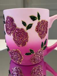 Sparkling Crystal Flower Mug with pink gradient design, adorned with pink crystal flowers and green leaves, close-up view.