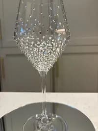 Luxury Crystal White Wine Glass with sparkling crystals, shown close-up in a graduated design, on a reflective surface.
