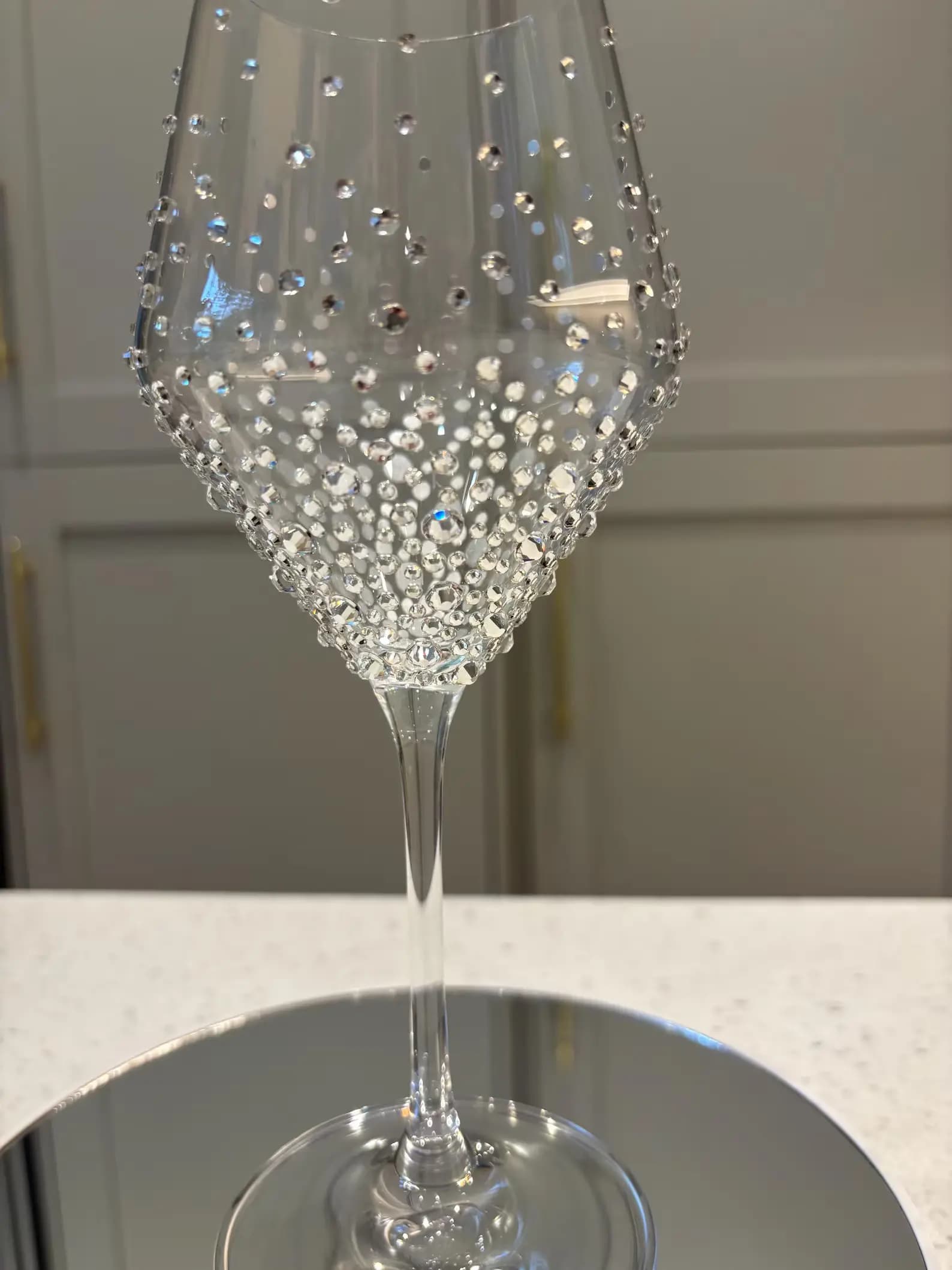 Luxury Crystal White Wine Glass with sparkling crystals, shown close-up in a graduated design, on a reflective surface.