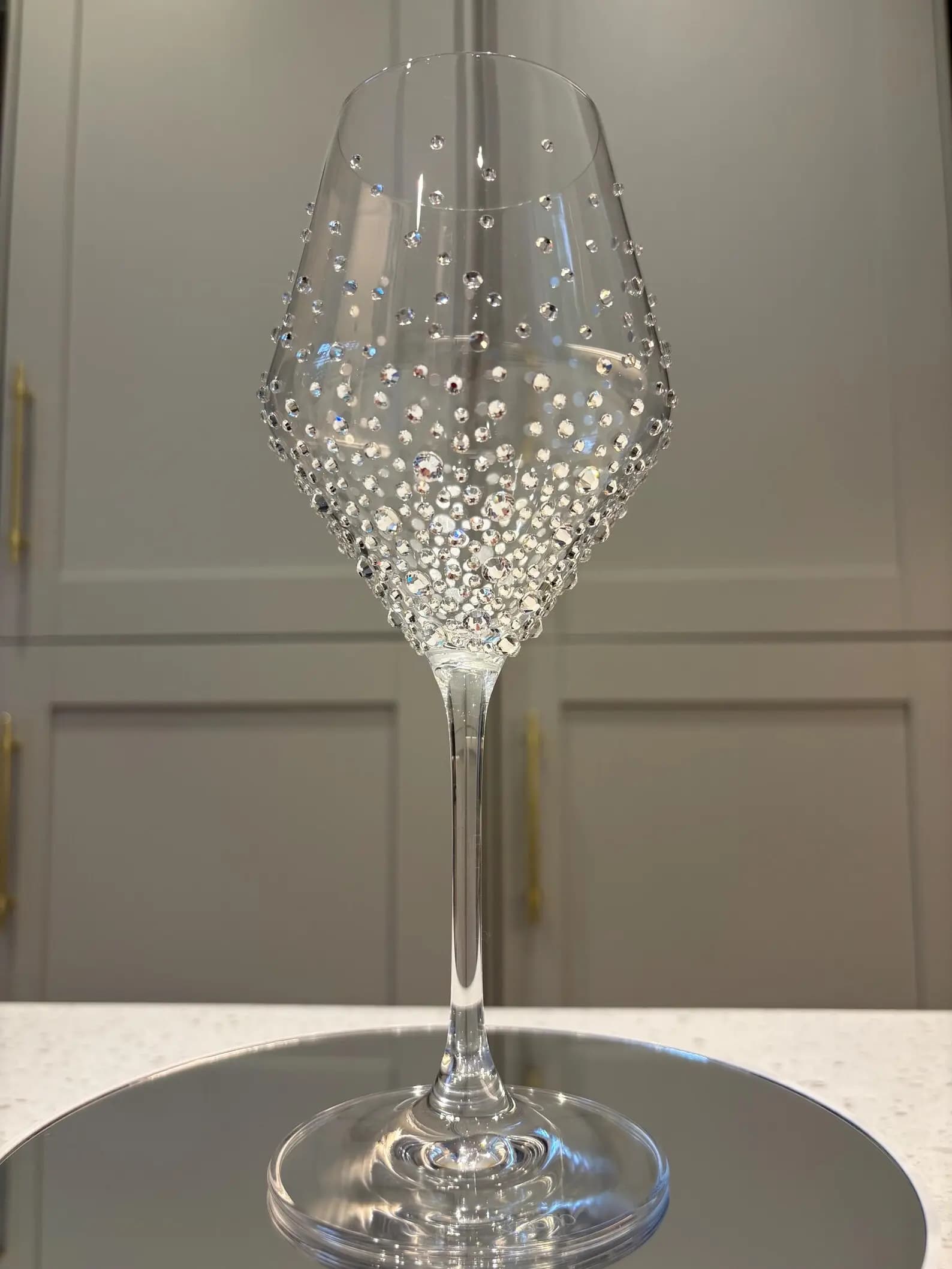 Luxury Crystal White Wine Glass, decorated with sparkling crystals in a graduated design, displayed on a reflective surface.